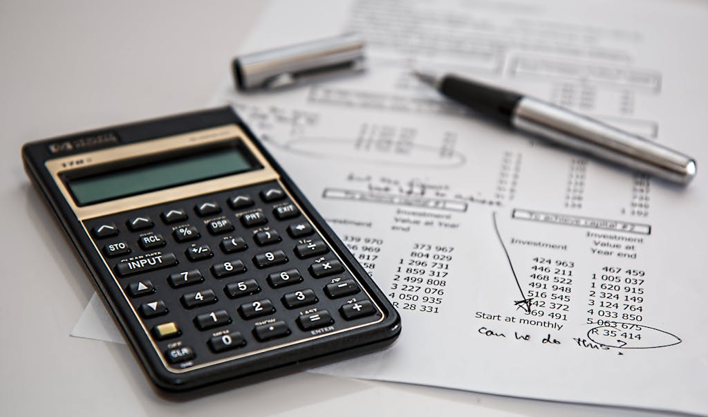 Close-up of financial documents with calculator and pen, ideal for business management themes.