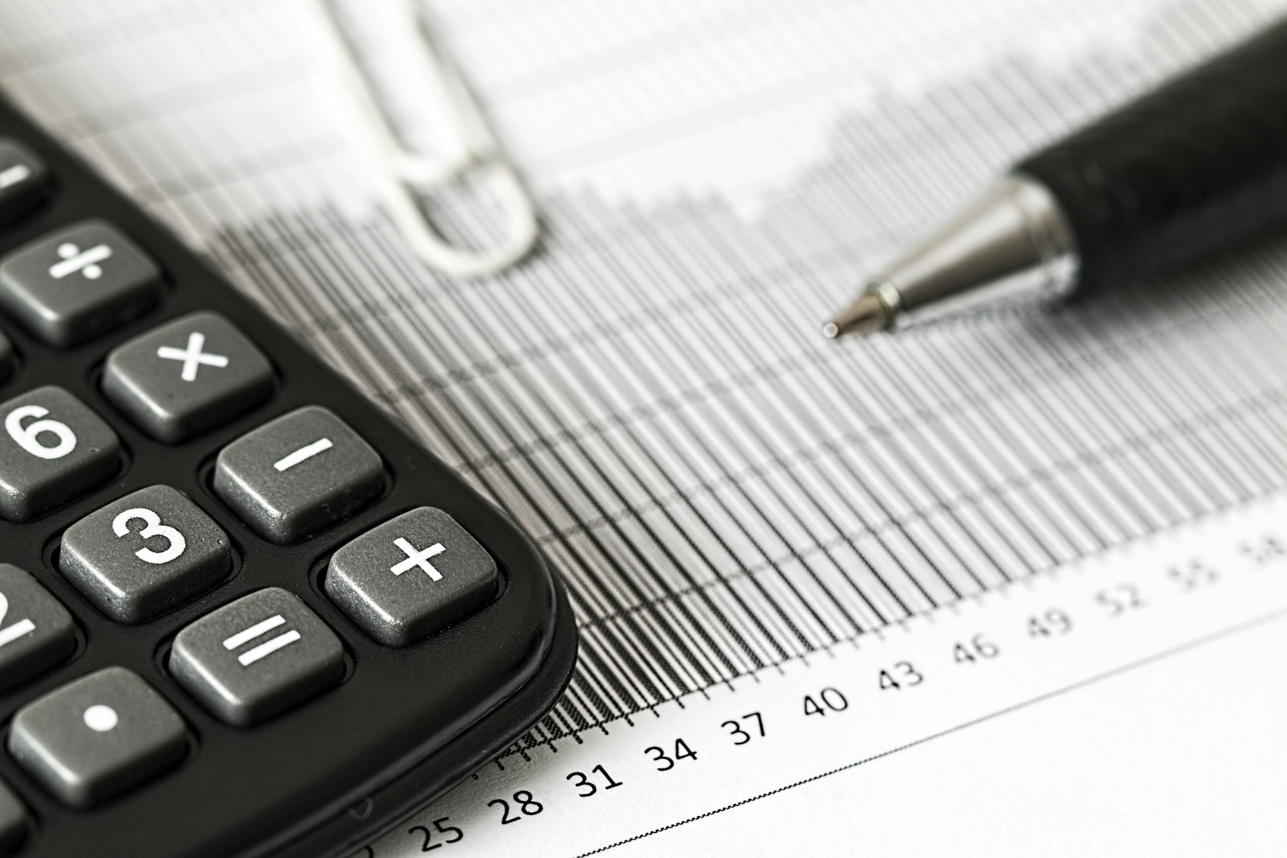 close up of a calculator and pen on a bar graph representing finance and accounting. 209224 scaled